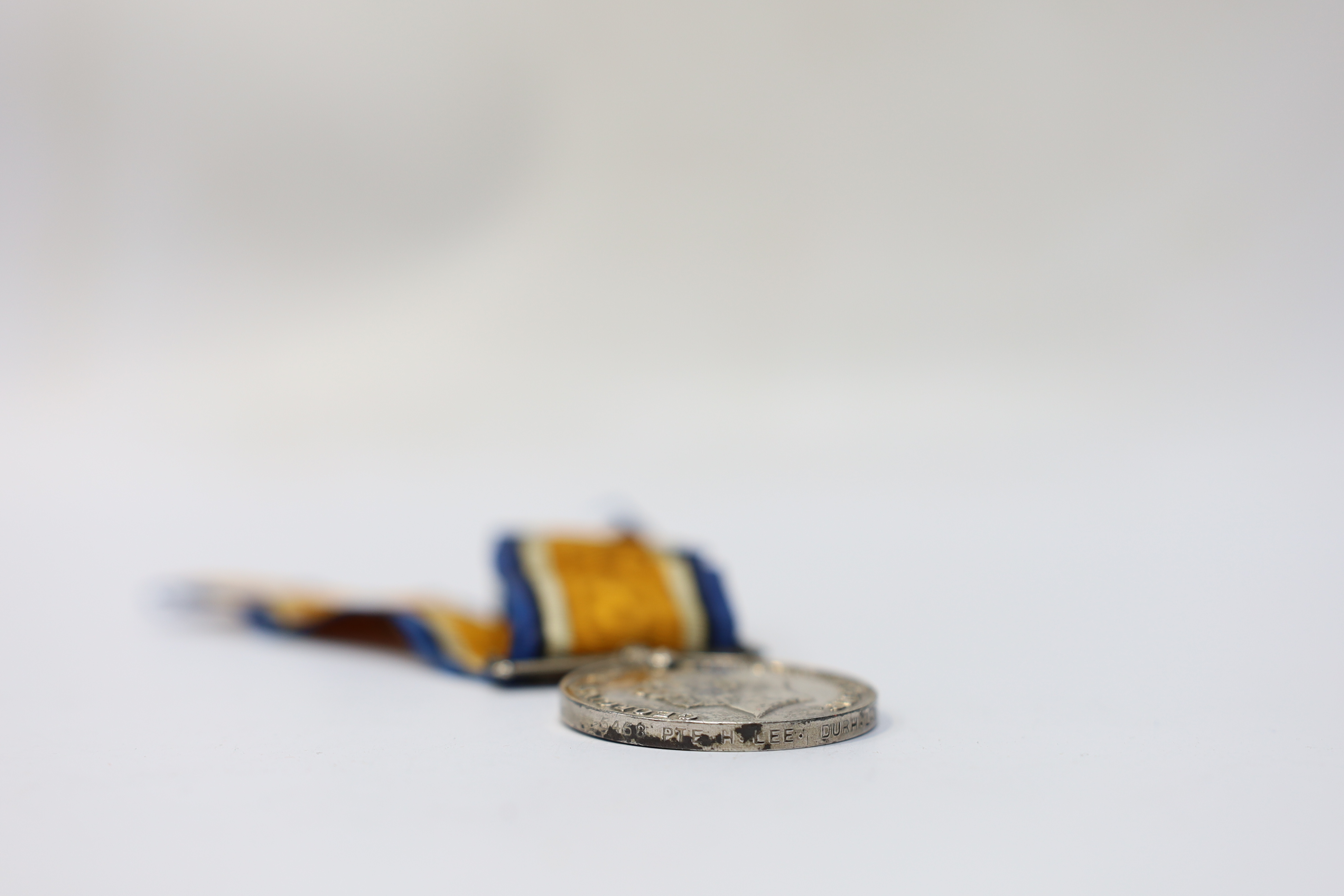 Seven medals including; a First World War British War Medal awarded to PTE. H. Lee DURH. L.I., A 1939-1945 medal, The Defence Medal, the Africa Star, the France and Germany Star, the 1939-1945 Star, plus a GPO cap badge.